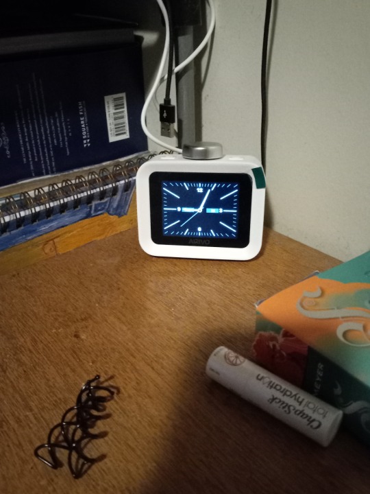 A small, white, digital alarm clock