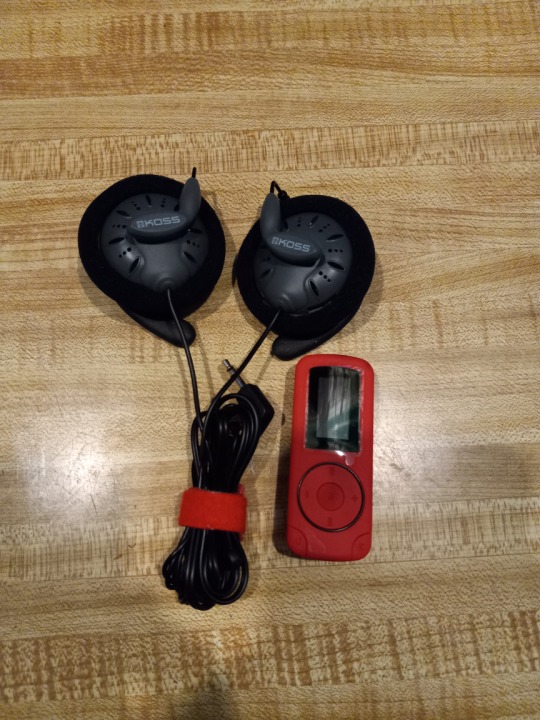 Clip-style headphones and a red mp3 player