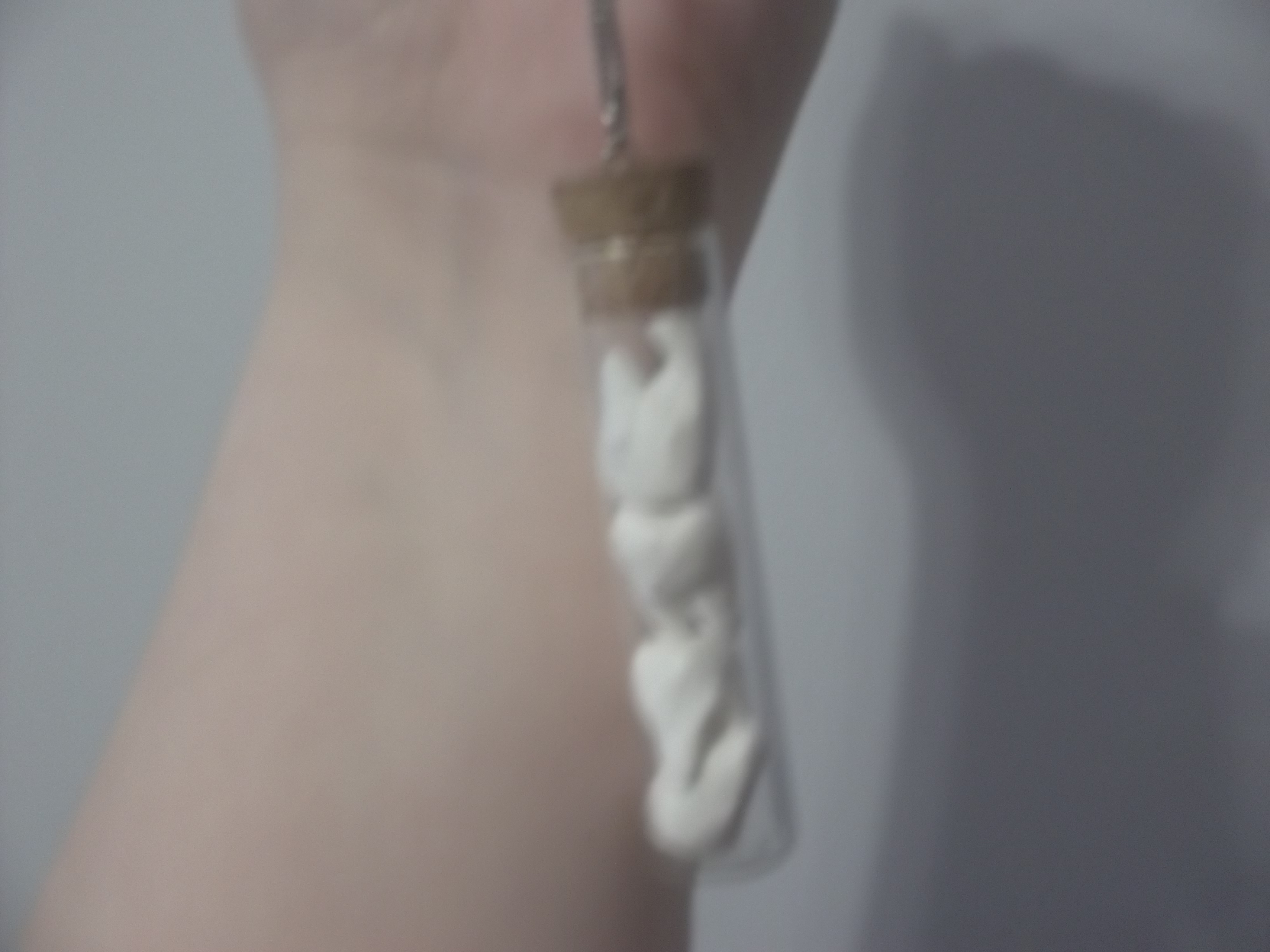 <image of tube charm with fake teeth inside>