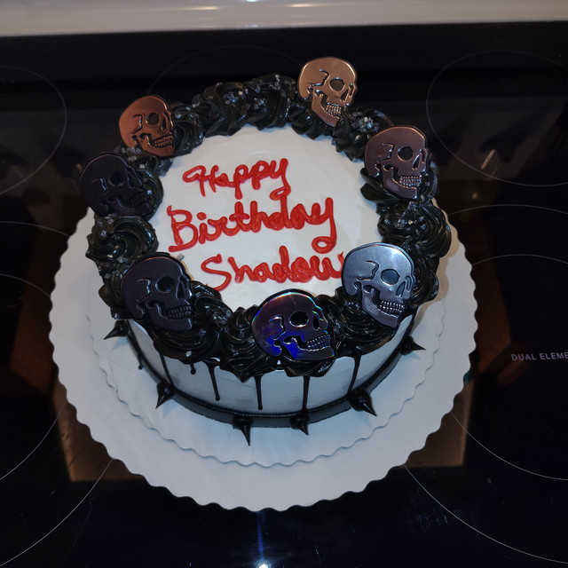 Birthday cake with skulls and small spikes around bottom.