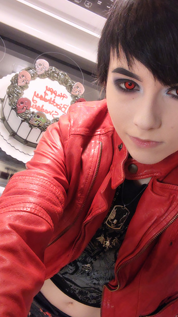Pale emo with birthday cake over their shoulder.