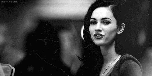 This may contain: a black and white photo of a woman with long dark hair, wearing a sweater