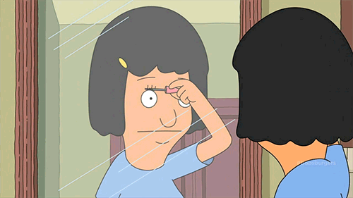 This may contain: a woman looking at herself in the mirror with her hand on her head and one eye open