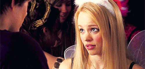 This may contain: a woman with long blonde hair wearing a santa hat