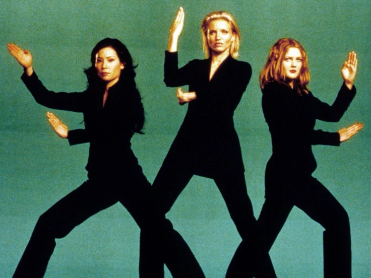 This may contain: three women in black outfits are dancing against a green background with their hands up to the side