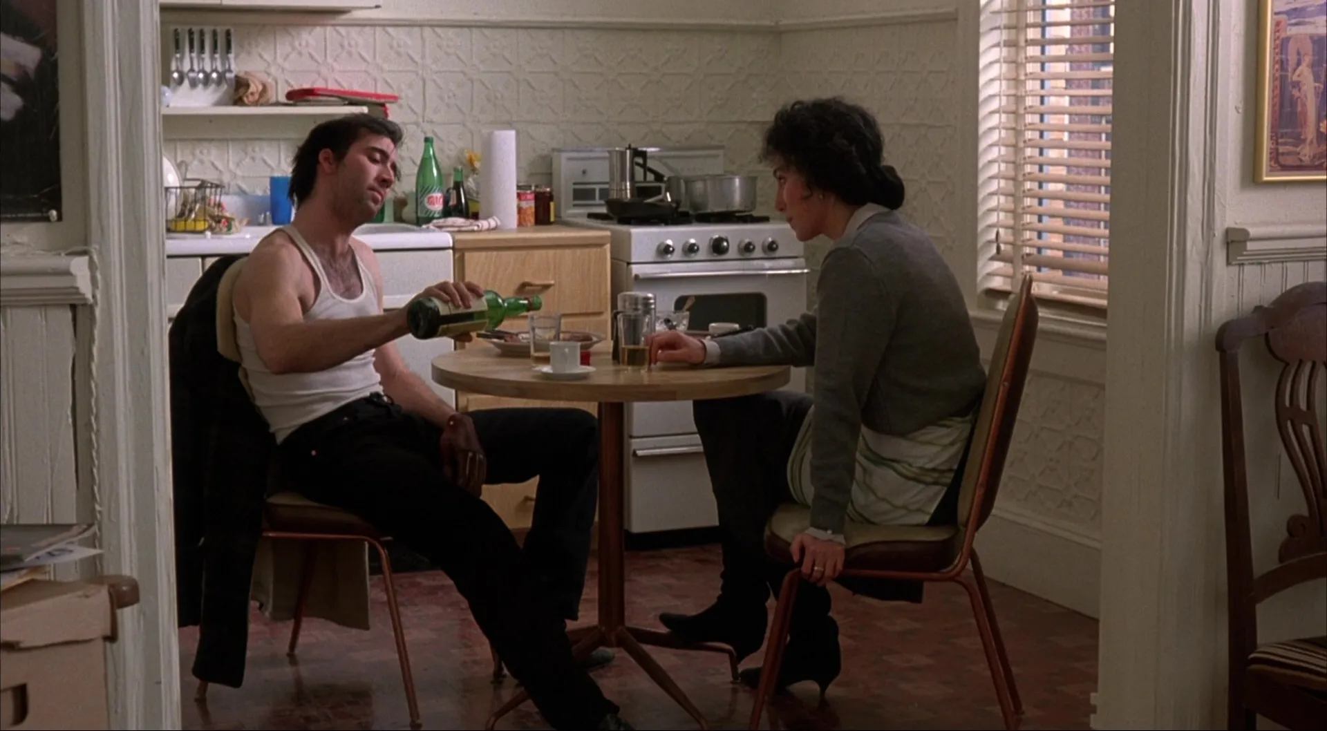 Cher and nicolas cage in a kitchen almost visibly arguing with each other