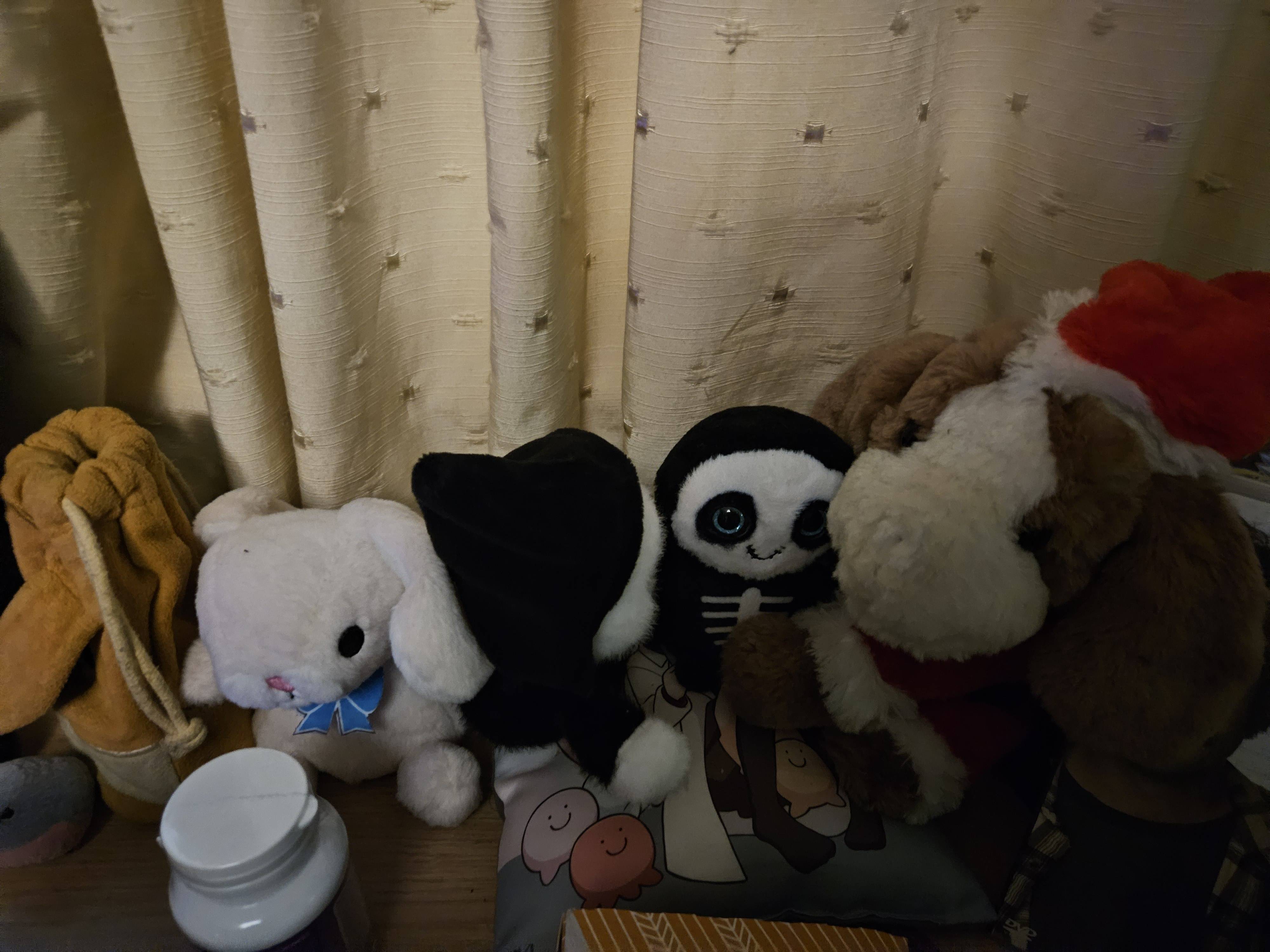 Left to right: a small pink bunny with a blue bow tie, a small grim reaper, a small skeleton, a bigger dog in a santa costume