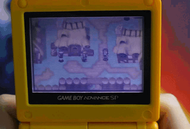 a yellow game boy advance sp displays a game