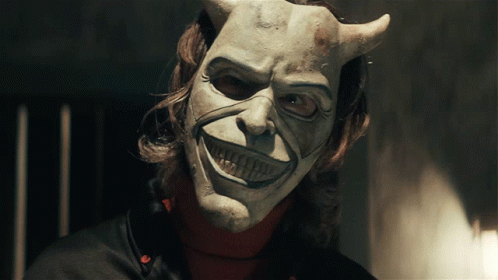 a man wearing a white mask with horns on his face