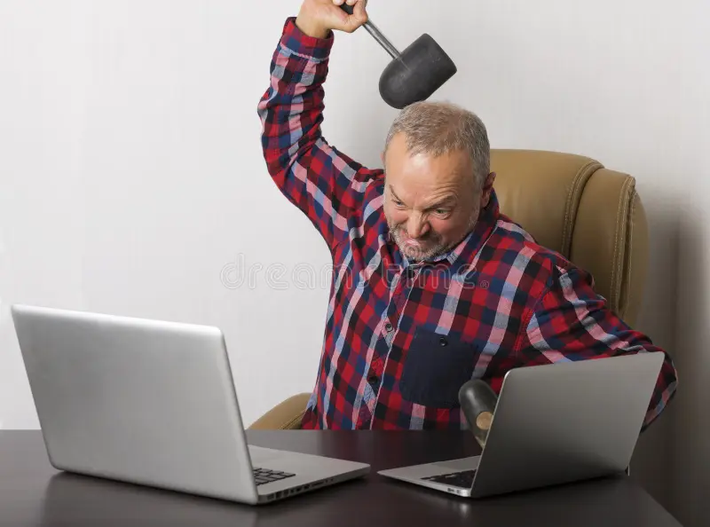 angry-man-crashing-laptop-hammer-61063155.jpg