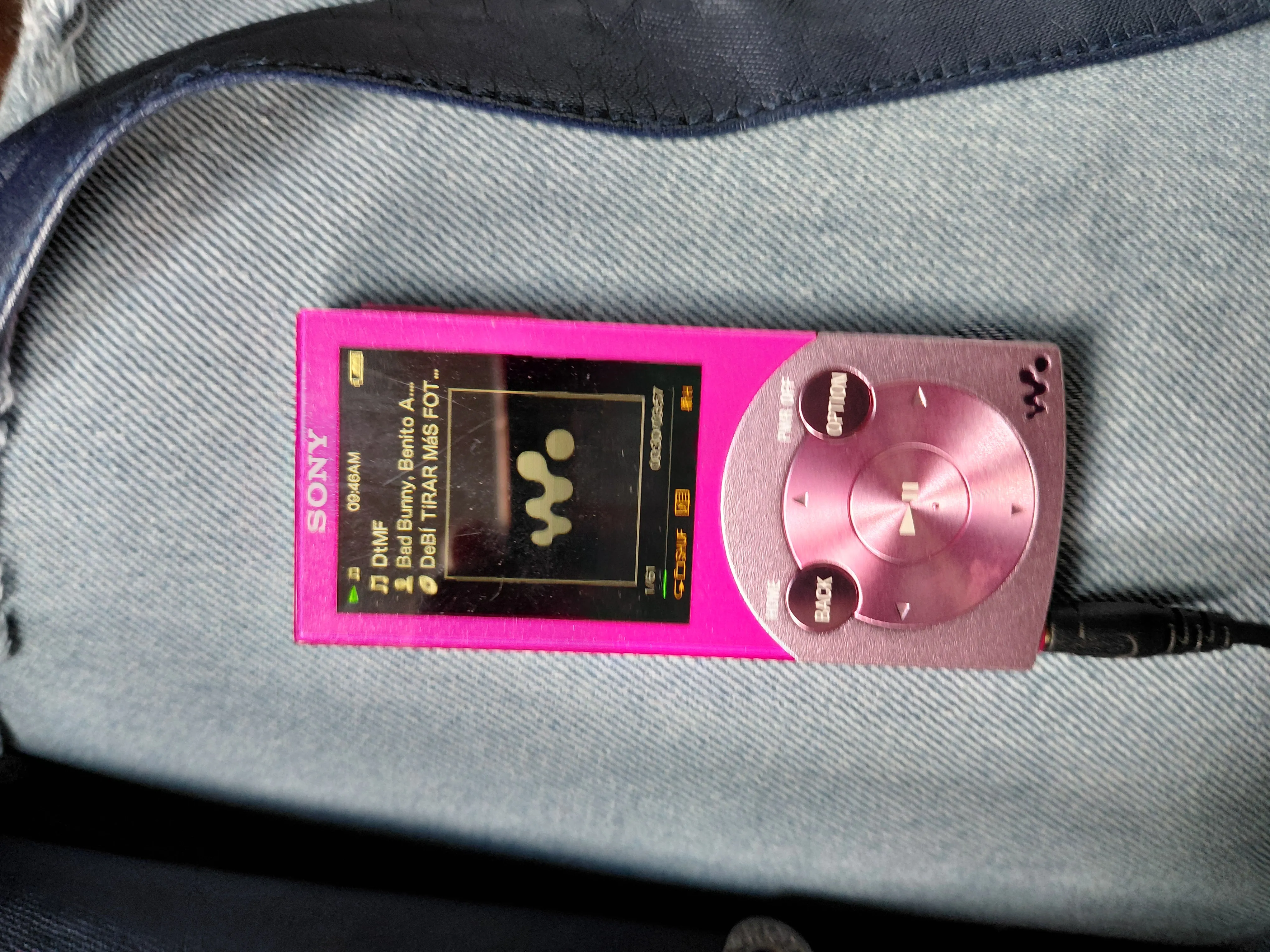 a neon pink Sony Walkman Mp3 Player, currently playing DtMF by Bad Bunny