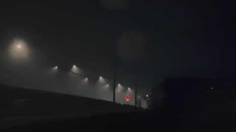 Streetlights under heavy fog look like cones